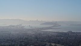 5K aerial stock footage a wide hazy view of Port of Oakland, Bay Bridge, and Downtown San Francisco skyline, California Aerial Stock Footage | AXSF09_014