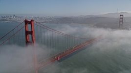 5K aerial stock footage fly through fog over Marin Hills, reveal famous and iconic Golden Gate Bridge and the distant San Francisco skyline, California Aerial Stock Footage | AXSF09_039