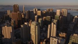 5K aerial stock footage tilt from city buildings to approach and fly over skyscrapers in Downtown San Francisco, California, sunset Aerial Stock Footage | AXSF10_023