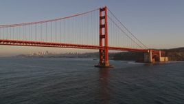 5K aerial stock footage of flying low under the Golden Gate Bridge, pan to reveal Downtown San Francisco, California, sunset Aerial Stock Footage | AXSF10_042