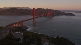 5K aerial stock footage pan across Highway 101 in Presidio, reveal Golden Gate Bridge, San Francisco, California, sunset Aerial Stock Footage | AXSF10_051