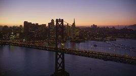 5K aerial stock footage flying by the Bay Bridge, skyline in the background, Downtown San Francisco, California, twilight Aerial Stock Footage | AXSF10_103