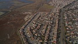 5K aerial stock footage of flying away from tract homes and marshland, Union City, California Aerial Stock Footage | AXSF11_008