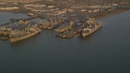 5K aerial stock footage flyby base and reveal USS Hornet and ships at Naval Air Station Alameda, California, sunset Aerial Stock Footage | AXSF14_001