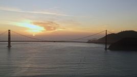 5K aerial stock footage of flying by the famous Golden Gate Bridge with view of setting sun, San Francisco, California, sunset Aerial Stock Footage | AXSF14_038