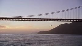 5K aerial stock footage fly low to approach Golden Gate Bridge, pan to reveal a cargo ship, San Francisco, California, twilight Aerial Stock Footage | AXSF14_063