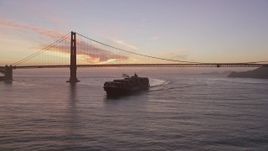 5K aerial stock footage track cargo ship sailing by the Golden Gate Bridge, San Francisco, California, twilight Aerial Stock Footage | AXSF14_067