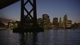 5K aerial stock footage fly low beneath Bay Bridge with a view of the Downtown San Francisco skyline, California, twilight Aerial Stock Footage | AXSF14_105