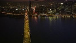 5K aerial stock footage pan across Downtown San Francisco, California, to reveal heavy traffic on the Bay Bridge, night Aerial Stock Footage | AXSF14_115