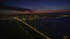 5K aerial stock footage of flying by the Bay Bridge, with a view of Downtown San Francisco skyscrapers, California, night Aerial Stock Footage | AXSF14_124