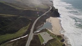 5K aerial stock footage tilt to Pomponio Creek and beach beside Highway 1 on the coast, San Gregorio, California Aerial Stock Footage | AXSF15_068