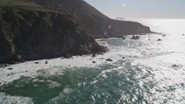 5K aerial stock footage tilt from ocean waves to reveal tall coastal cliffs, Big Sur, California Aerial Stock Footage | AXSF16_073