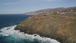 5K aerial stock footage of flying away from the Point Sur Light Station on coastal cliffs, Big Sur, California Aerial Stock Footage | AXSF16_086