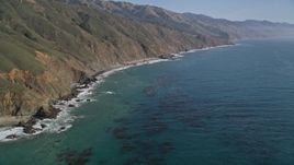 5K aerial stock footage of flying over the ocean, tilt up to reveal coastal cliffs, Big Sur, California Aerial Stock Footage | AXSF16_105