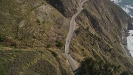 5K aerial stock footage of flying over the Highway 1 road atop coastal cliffs, tilt to cars, Big Sur, California Aerial Stock Footage | AXSF16_113