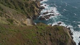 5K aerial stock footage tilt from waves crashing and approach cliffs on the coast, then tilt back down to the water, Big Sur, California Aerial Stock Footage | AXSF16_117