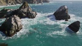 5K aerial stock footage of flying between large rock formations, tilt revealing coastal cliffs, Big Sur, California Aerial Stock Footage | AXSF16_120