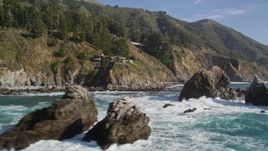 5K aerial stock footage tilt from the ocean to reveal rock formations, home atop coastal cliff, Big Sur, California Aerial Stock Footage | AXSF16_124