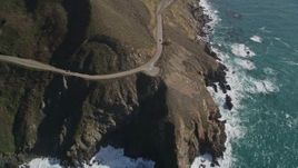 5K aerial stock footage of flying by small beach, pan right to Highway 1 atop coastal cliffs, Big Sur, California Aerial Stock Footage | AXSF16_129