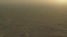 HD stock footage aerial video of a desert road through sand dunes at sunrise in Al Gharbia, Abu Dhabi, UAE Aerial Stock Footage | CAP_001_001