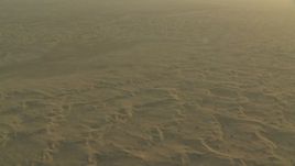 HD stock footage aerial video of flying over hazy desert sand dunes at sunrise, Al Gharbia, Abu Dhabi, UAE Aerial Stock Footage | CAP_001_007