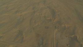 HD stock footage aerial video of buildings and desert sand dunes at sunrise, Al Gharbia, Abu Dhabi, UAE Aerial Stock Footage | CAP_001_010