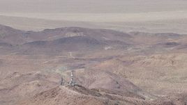 HD stock footage aerial video of a reverse view of a group of radio towers and Mojave Desert mountains in San Bernardino County, California Aerial Stock Footage | CAP_006_019