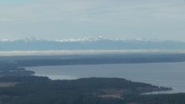 HD stock footage aerial video of the snowy Olympic Mountain range seen from Puget Sound, Washington Aerial Stock Footage | CAP_009_007
