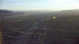 HD stock footage aerial video follow power lines through the desert to approach I-40 in Daggett, California at sunrise Aerial Stock Footage | CAP_011_002