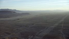 HD stock footage aerial video approach I-40 and a train in the desert in Daggett, California at sunrise Aerial Stock Footage | CAP_011_003
