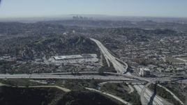 HD stock footage aerial video of the 2 and 134 freeway interchange in Glendale, California, Downtown Los Angeles skyline in background Aerial Stock Footage | CAP_012_011