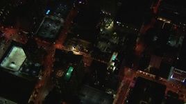HD stock footage aerial video tilt from AT&T Center to bird's eye of rooftop hotel pool and street at night, Midtown Atlanta, Georgia Aerial Stock Footage | CAP_013_039