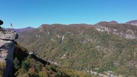 2.7K stock footage aerial video of flying by the rock formation to approach mountains at Chimney Rock in North Carolina Aerial Stock Footage | CAP_014_005