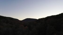 2.7K stock footage aerial video ascend over forest for view of distant mountains at sunset, Chimney Rock, North Carolina Aerial Stock Footage | CAP_014_015