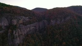 2.7K stock footage aerial video wide reverse view of forest and a clifftop waterfall at sunset, Chimney Rock, North Carolina Aerial Stock Footage | CAP_014_021