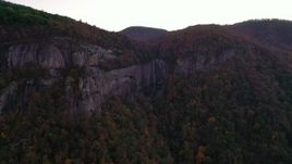 2.7K stock footage aerial video wide reverse view of forest, mountains, and a clifftop waterfall at sunset, Chimney Rock, North Carolina Aerial Stock Footage | CAP_014_022