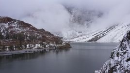 4K stock footage aerial video passing snowy mountain slopes to reveal the lake, Inyo National Forest, California Aerial Stock Footage | CAP_015_012