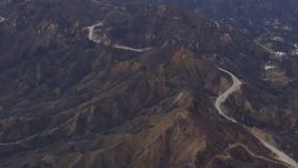 HD stock footage aerial video of flying by road by mountains scarred by fire, Malibu, California Aerial Stock Footage | CAP_018_014