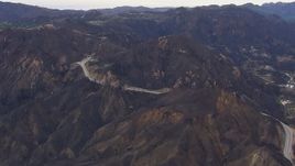 HD stock footage aerial video of road and tunnels by mountains scarred by fire, Malibu, California Aerial Stock Footage | CAP_018_015