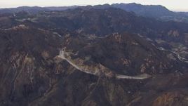 HD stock footage aerial video of flying by road and tunnels by mountains scarred by fire, Malibu, California Aerial Stock Footage | CAP_018_016