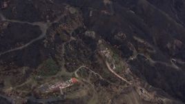HD stock footage aerial video fly away from and orbit hillside homes destroyed by fire, Malibu, California Aerial Stock Footage | CAP_018_025