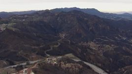 HD stock footage aerial video reverse view of hillside homes destroyed by fire by scorched mountains, Malibu, California Aerial Stock Footage | CAP_018_027