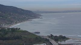 HD stock footage aerial video of flying toward Malibu Pier and oceanfront homes with a view of DTLA skyline at sunset, Malibu, California Aerial Stock Footage | CAP_018_051