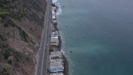 HD stock footage aerial video of oceanfront homes by PCH at sunset, Malibu, California Aerial Stock Footage | CAP_018_059