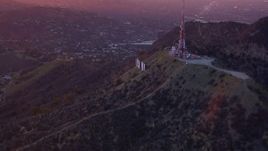 HD stock footage aerial video of orbiting radio towers atop Hollywood Hills, reveal Hollywood Sign at sunset, California Aerial Stock Footage | CAP_018_082