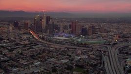 HD stock footage aerial video of flying away from Downtown Los Angeles skyscrapers at sunset, California Aerial Stock Footage | CAP_018_100