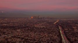HD stock footage aerial video of a view of the distant Downtown Los Angeles skyline at sunset, California Aerial Stock Footage | CAP_018_105