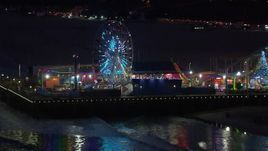 HD stock footage aerial video of the Ferris wheel and rides at night, Santa Monica Pier, California Aerial Stock Footage | CAP_018_113