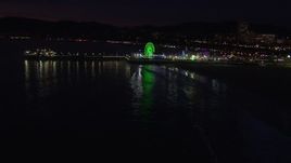 HD stock footage aerial video approach the Ferris wheel and rides at nighttime, Santa Monica Pier, California Aerial Stock Footage | CAP_018_118