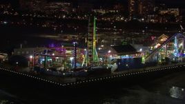 HD stock footage aerial video circling the Ferris wheel and rides at nighttime, Santa Monica Pier, California Aerial Stock Footage | CAP_018_120
